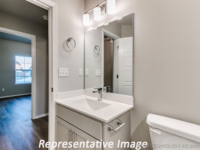 bathroom featuring vanity, hardwood / wood-style flooring, and toilet