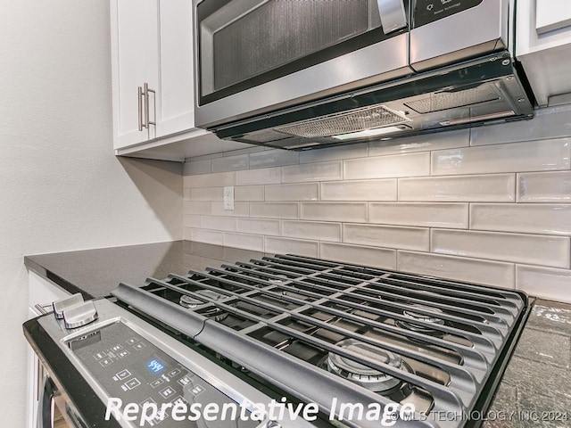 room details featuring decorative backsplash, white cabinetry, and stainless steel appliances