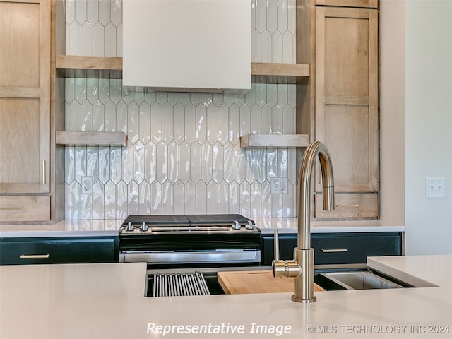 kitchen featuring decorative backsplash, light brown cabinets, and stainless steel range