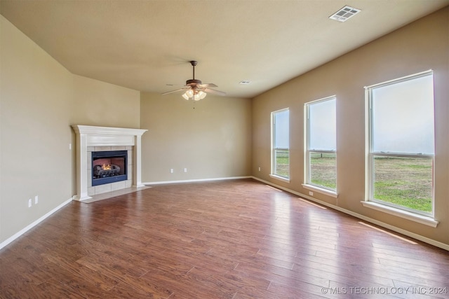 unfurnished living room featuring hardwood / wood-style flooring, ceiling fan, and a fireplace