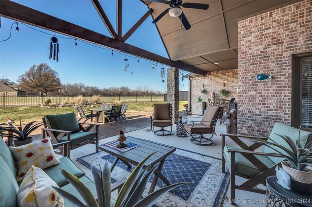 view of patio with an outdoor living space, a rural view, and ceiling fan