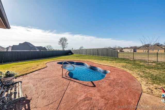 view of pool featuring a lawn and a patio