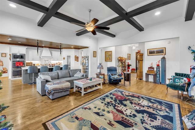 living room featuring beamed ceiling, ceiling fan, and light hardwood / wood-style flooring