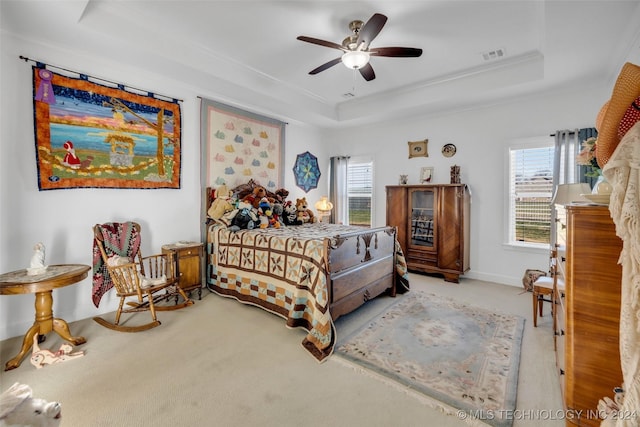 bedroom with a tray ceiling, ceiling fan, and light colored carpet