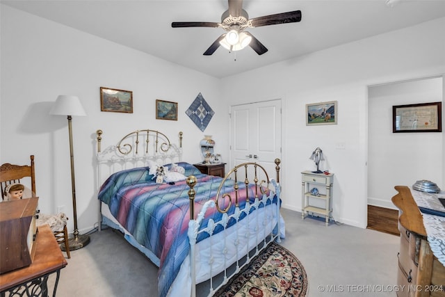 bedroom with ceiling fan, light colored carpet, and a closet