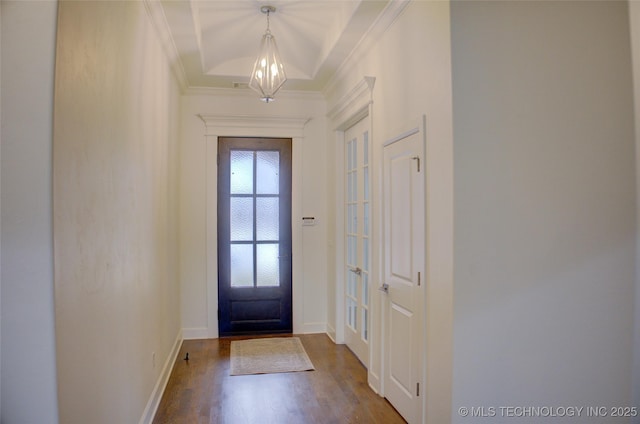 foyer featuring crown molding, wood-type flooring, and a chandelier