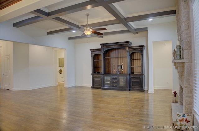 unfurnished living room featuring ceiling fan, beam ceiling, washer / dryer, and light wood-type flooring