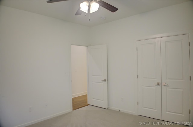 unfurnished bedroom with light colored carpet, a closet, and ceiling fan