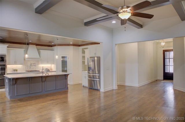 kitchen featuring stainless steel appliances, custom exhaust hood, a kitchen island with sink, and white cabinets