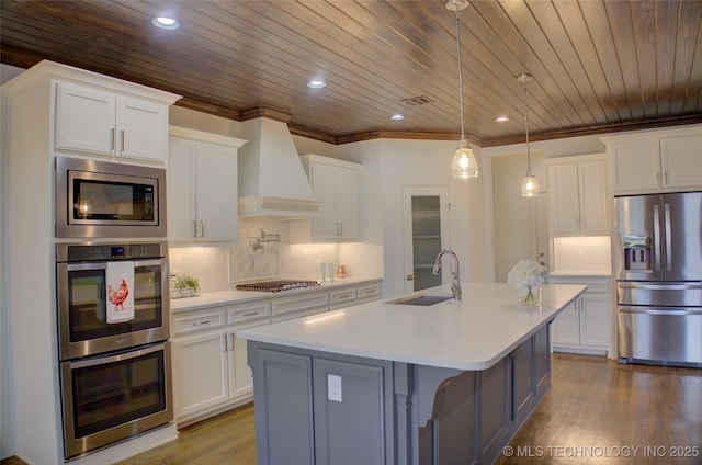 kitchen featuring white cabinetry, appliances with stainless steel finishes, sink, and custom range hood