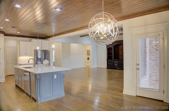 kitchen with sink, white cabinetry, appliances with stainless steel finishes, an island with sink, and pendant lighting