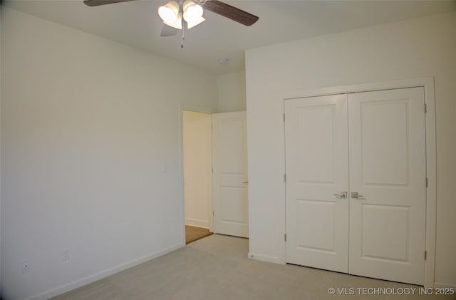 unfurnished bedroom featuring light colored carpet, ceiling fan, and a closet