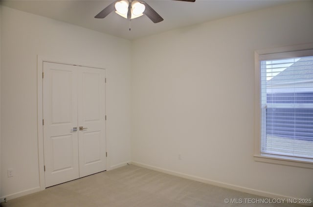 carpeted spare room with a wealth of natural light and ceiling fan