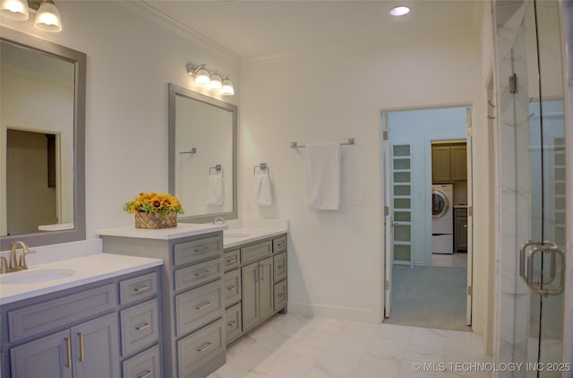 bathroom with ornamental molding, washer / dryer, a shower with door, and vanity