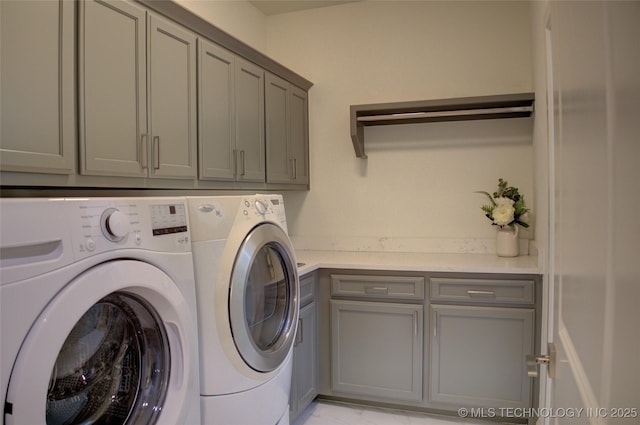 washroom with cabinets and washer and clothes dryer