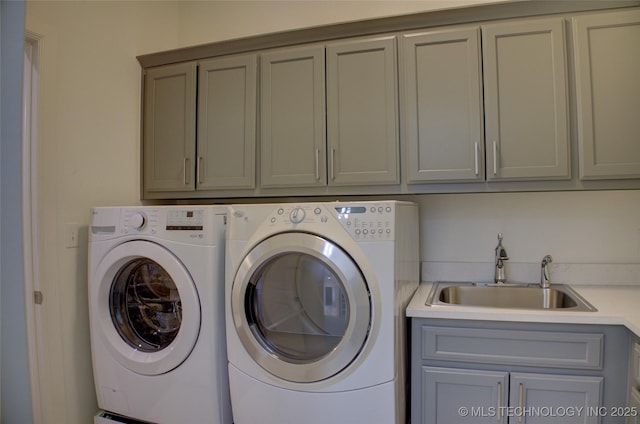 washroom featuring cabinets, sink, and washing machine and dryer