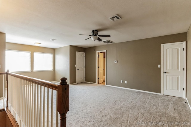 spare room featuring light carpet and ceiling fan