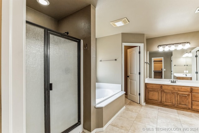 bathroom with tile patterned floors, vanity, and shower with separate bathtub