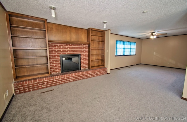 unfurnished living room featuring a fireplace, a textured ceiling, carpet floors, and ceiling fan