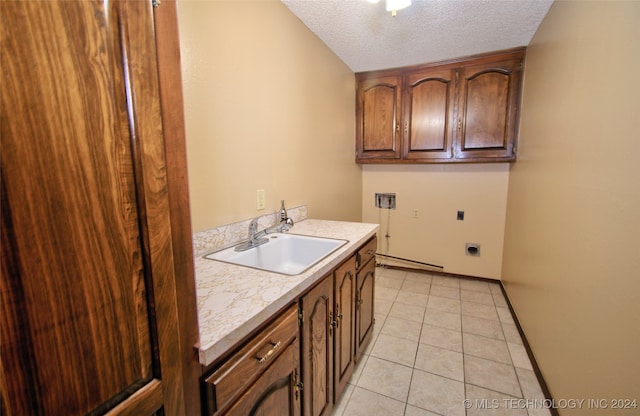 washroom with hookup for an electric dryer, cabinets, a textured ceiling, sink, and light tile patterned floors