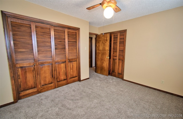 unfurnished bedroom with ceiling fan, a textured ceiling, light carpet, and a closet