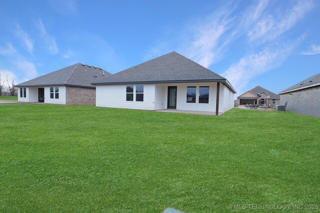 back of house featuring central AC unit, a yard, and a patio area