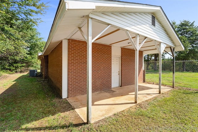 view of outdoor structure with central air condition unit and a yard