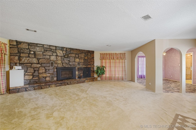 unfurnished living room with carpet flooring, a fireplace, and a textured ceiling