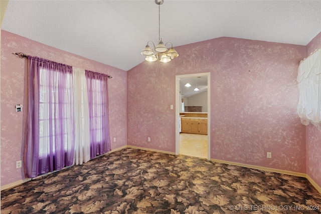 empty room with vaulted ceiling and a notable chandelier