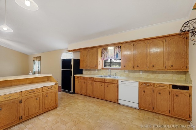 kitchen featuring white dishwasher, black fridge, sink, and tasteful backsplash