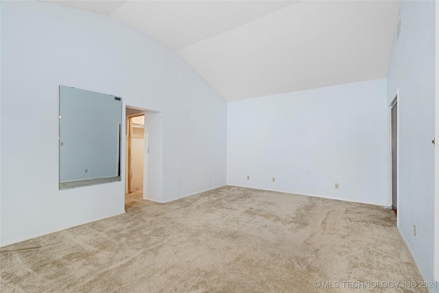 carpeted spare room with vaulted ceiling