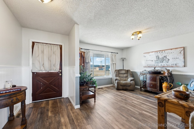 foyer entrance featuring dark hardwood / wood-style flooring and a textured ceiling