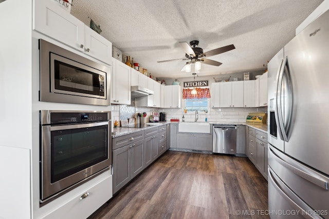 kitchen with sink, gray cabinetry, a textured ceiling, appliances with stainless steel finishes, and white cabinets