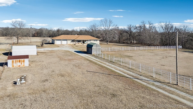 view of yard featuring a garage and a rural view