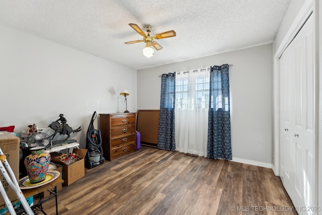 bedroom with a textured ceiling, ceiling fan, and a closet