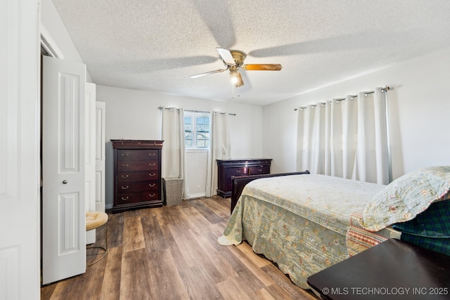 bedroom with hardwood / wood-style flooring, a textured ceiling, a closet, and ceiling fan