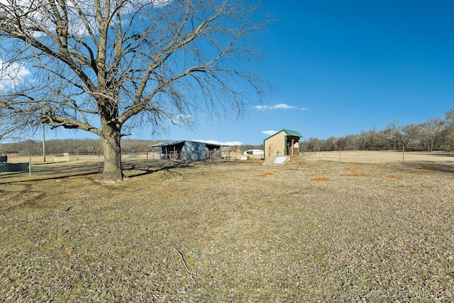 view of yard featuring an outdoor structure and a rural view