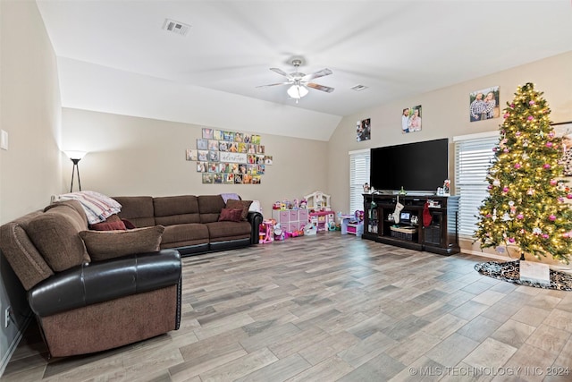 living room featuring ceiling fan, vaulted ceiling, and light hardwood / wood-style flooring