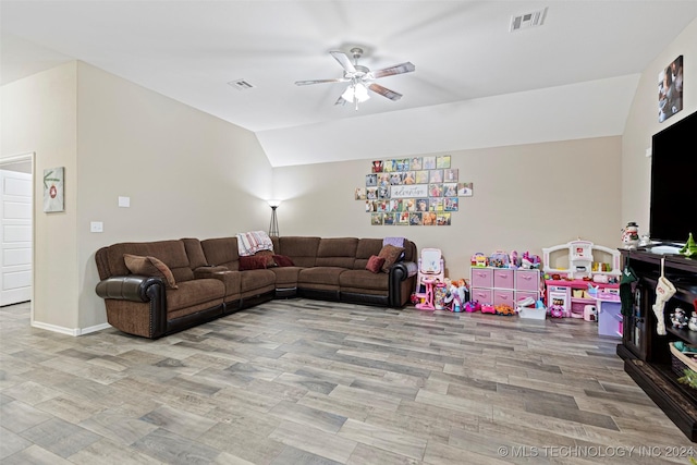 living room featuring ceiling fan, light hardwood / wood-style floors, and vaulted ceiling