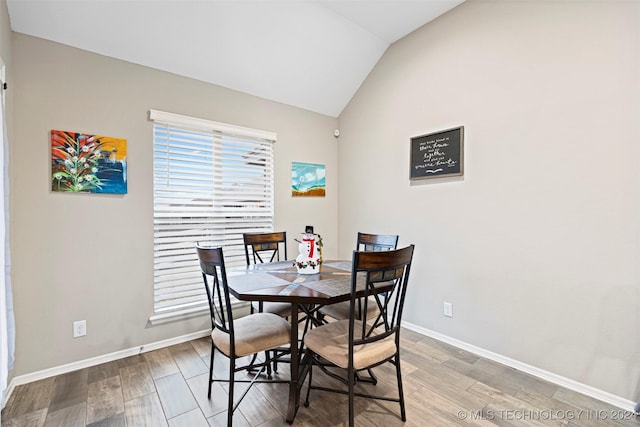 dining space featuring hardwood / wood-style flooring and lofted ceiling