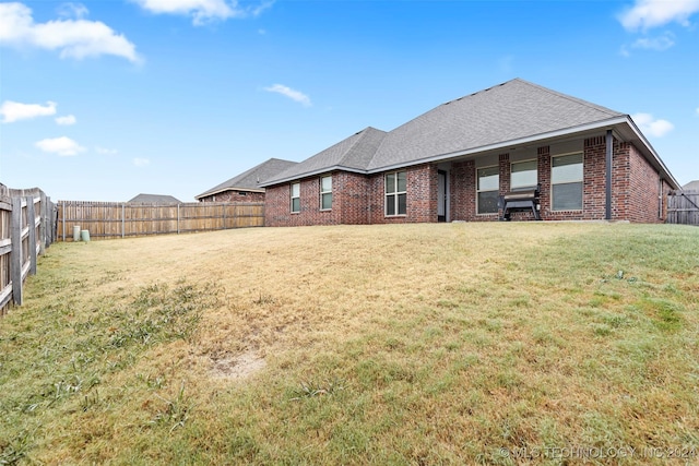 rear view of house featuring a yard