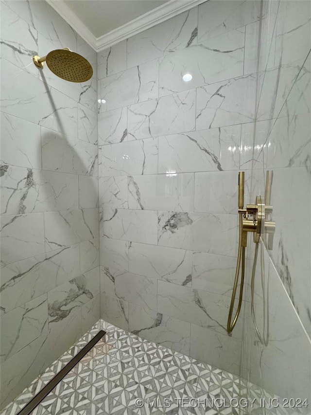 bathroom with crown molding and a tile shower