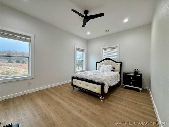 bedroom with multiple windows, ceiling fan, and light wood-type flooring