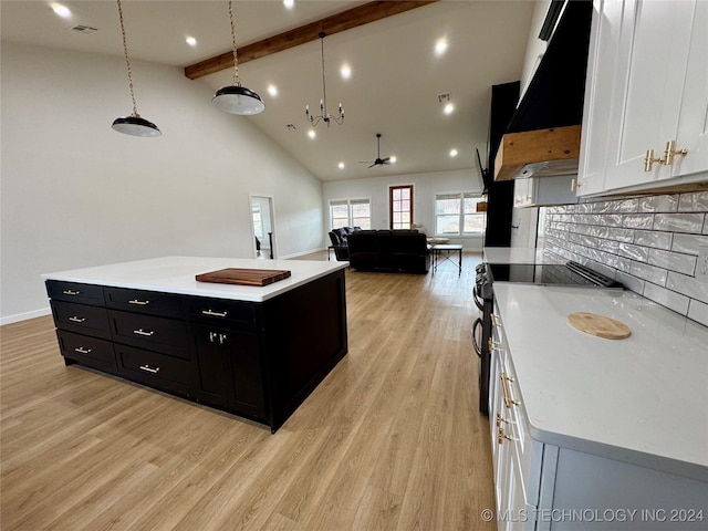 kitchen with pendant lighting, custom range hood, white cabinets, and a center island