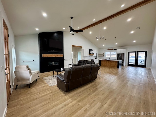 living room with beamed ceiling, high vaulted ceiling, a large fireplace, and light hardwood / wood-style floors