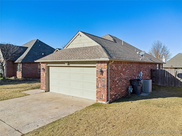 view of home's exterior featuring a garage, a yard, and central AC