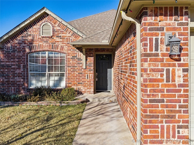 doorway to property featuring a lawn