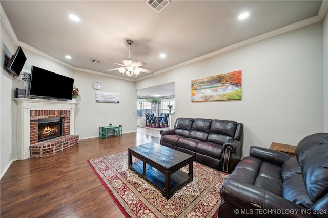 living room featuring a fireplace, wood-type flooring, ceiling fan, and ornamental molding