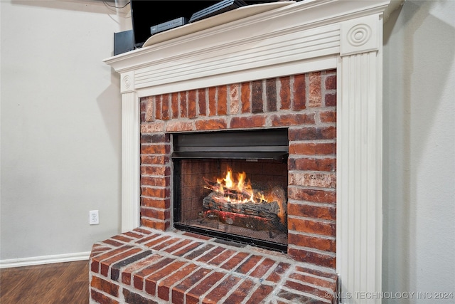 details featuring hardwood / wood-style flooring and a brick fireplace