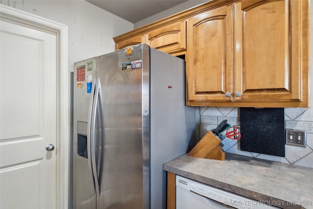 kitchen with stainless steel fridge, backsplash, and white dishwasher